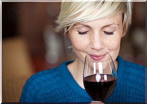 Woman smells red wine
