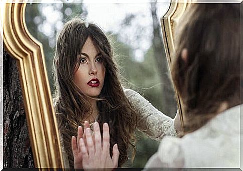 Woman looks at emotional damage in the mirror